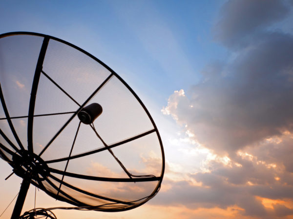 Big telecommunication satellite dish over sunset sky