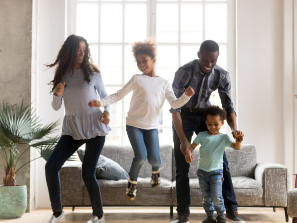 Happy black African family dancing at home