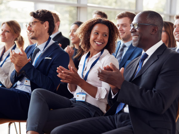 Smiling audience applauding at a business seminar