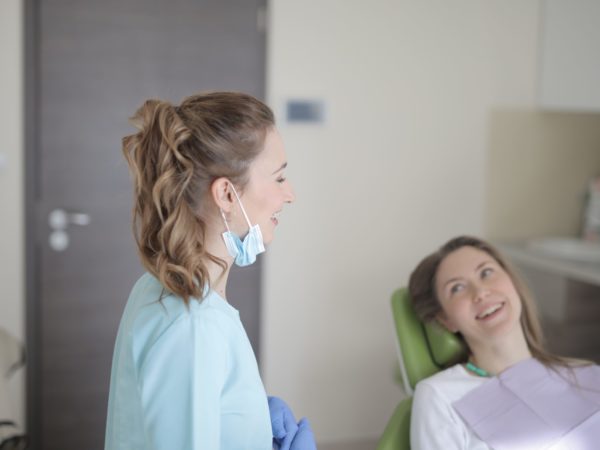 dentist and client in office for routine oral health exam