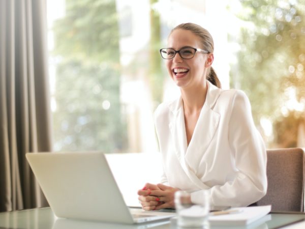 young professional woman smiling in front of laptop