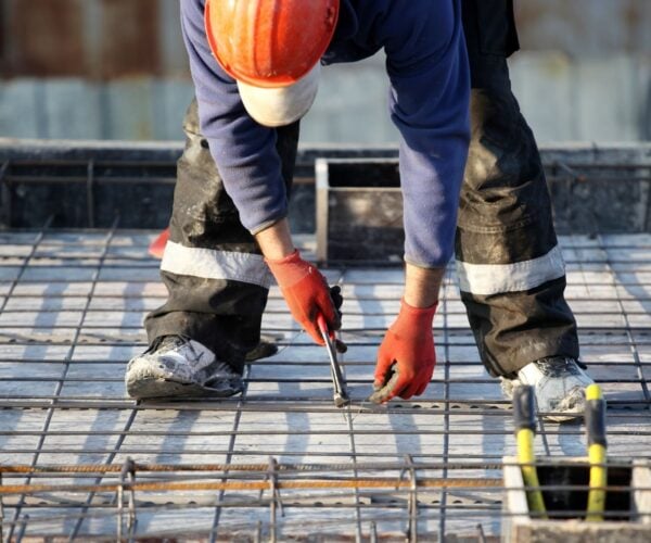 construction worker bending down for wire construction worker bending down for wire