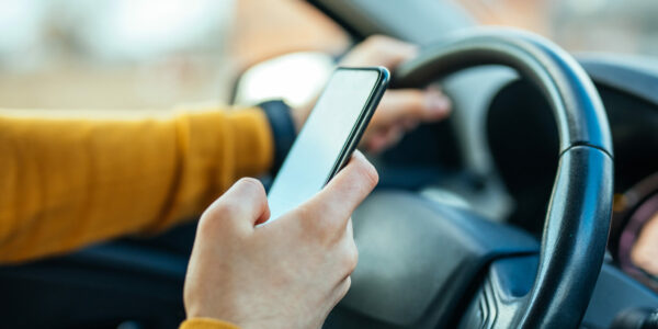 Shot of a male using mobile phone while driving the car.