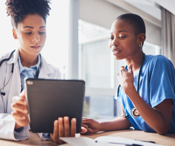 Tablet, black people or nurses with medical research reading news or tests results in hospital together. Teamwork, digital tech or African doctors planning or speaking of healthcare report on website.