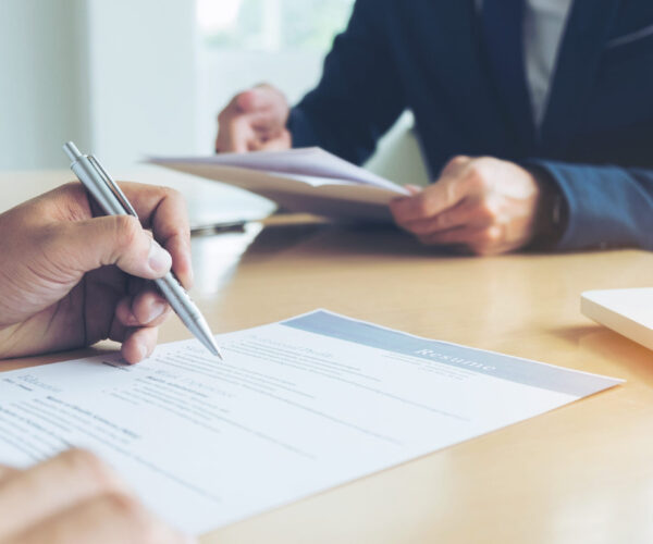 Executive reading a resume during a job interview and businessma Executive reading a resume during a job interview and businessman Completing Application Form. Hiring concept.