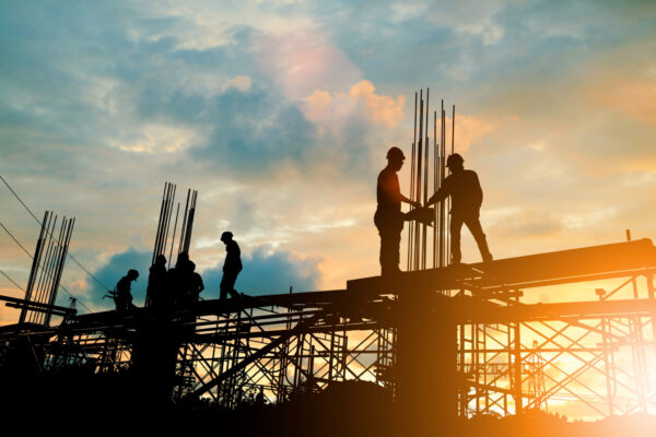 Silhouette of engineer and construction team working at site ove Silhouette of engineer and construction team working at site over blurred background sunset pastel for industry background with Light fair.