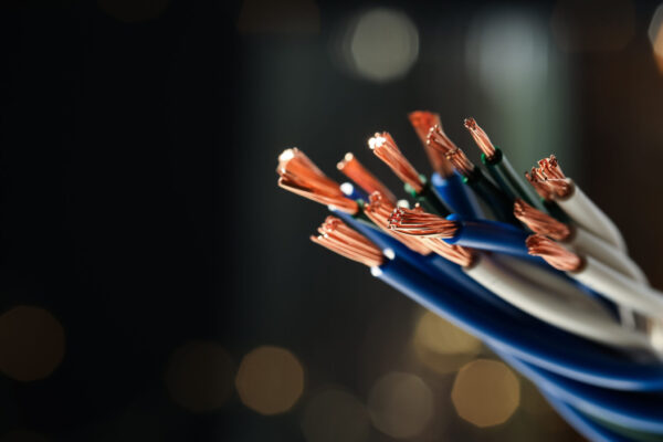 Stranded copper wires with insulation against blurred background Stranded copper wires with insulation against blurred background, closeup. Space for text