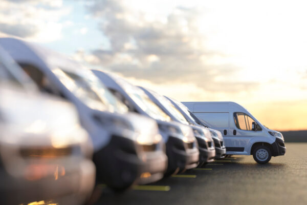 Generic row of new vans in a parking bay ready for purchase 3d render