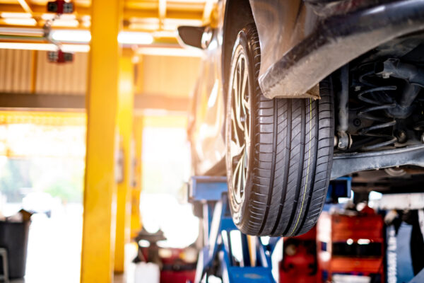 car automobile mechanic working on repairing the wheel tire of vehicle, taking car in for service workshop for male car mechanic fixing problems replacing broken parts of using tools and equipment car automobile mechanic working on repairing the wheel tire of vehicle, taking car in for service workshop for male car mechanic fixing problems replacing broken parts of using tools and equipment